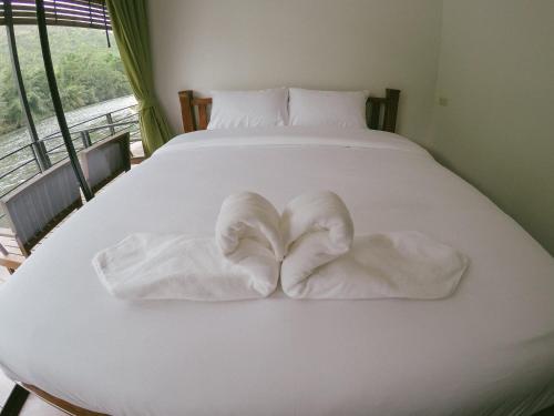 a white bed with two folded towels on it at Baan Krupong in Ban Tha Thong Mon