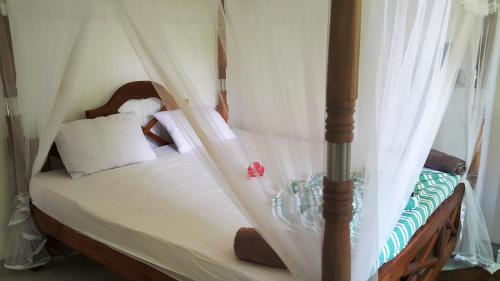a bedroom with a bed with a canopy at Era Holiday House in Mirissa