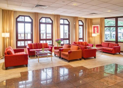 a living room filled with couches and chairs at Golden Tulip Bielefeld City in Bielefeld