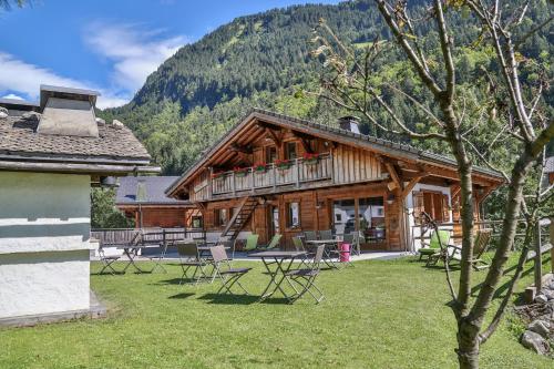 a log cabin with a deck and chairs in the yard at Bed and Breakfast Chalet Manava in Morzine