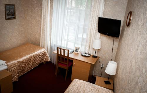 a hotel room with a desk and a bed and a window at Dom Dostoevskogo in Saint Petersburg