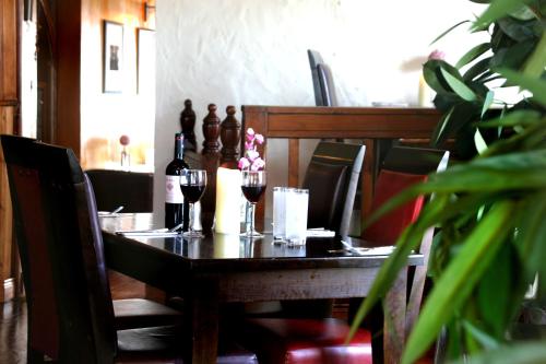 a wooden table with two glasses of wine and flowers at Maddens Bridge Bar & Guesthouse in Bundoran