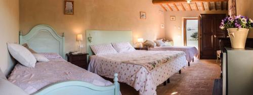 a bedroom with two beds and flowers on the wall at Casale Talevi in Cartoceto