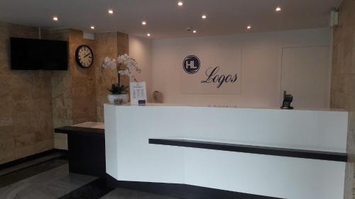 a large white counter in a room with a clock at Hotel Logos in Warsaw