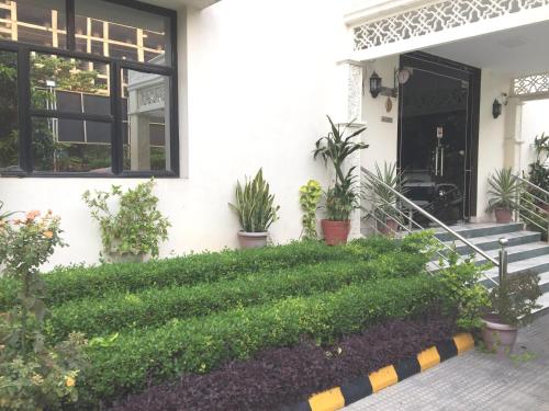 a white house with plants on the front porch at Angel Residency in Greater Noida