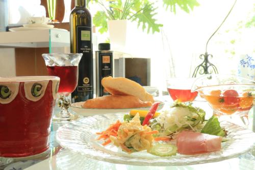 a table with a plate of food and a bottle of wine at Hitoyoshi Morinohall Ladies in - Female Only in Hitoyoshi