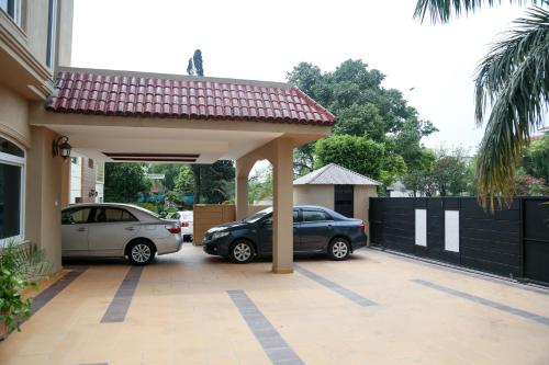 two cars parked in a garage next to a house at Grace Boutique Hotel in Islamabad