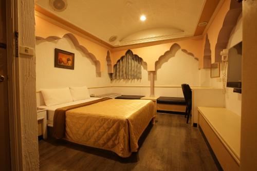a hotel room with a bed and a chair in it at Hua Yue Hotel in Taoyuan