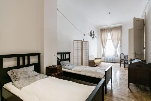 ブダペストにあるMolnar 21 Apartmentのベッド3台、テーブル、椅子が備わる客室です。