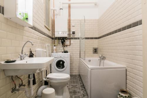 a bathroom with a toilet and a sink and a washing machine at Molnar 21 Apartment in Budapest