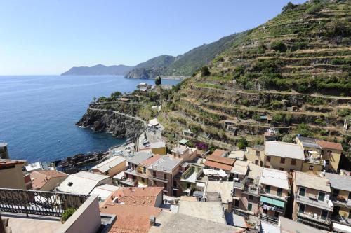 a village on a hill next to the ocean at Le Storie di Manarola in Manarola