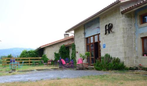 a building with chairs and tables outside of it at Hotel Alma de Romero in Carranza