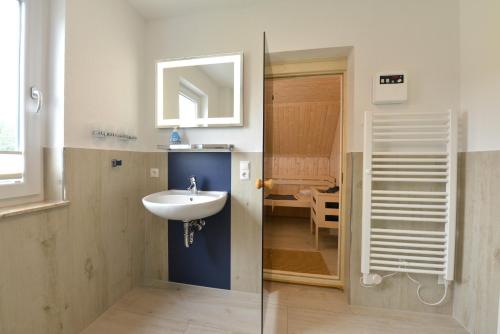 ein Bad mit einem Waschbecken und einem Spiegel in der Unterkunft Ferienhaus Ausguck in Breege
