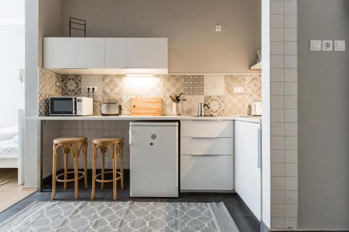 ブダペストにあるRevay 2 Apartmentの小さなキッチン(白い家電製品、スツール付)
