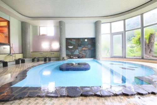 a large swimming pool in a room with windows at Micasa in Minakami