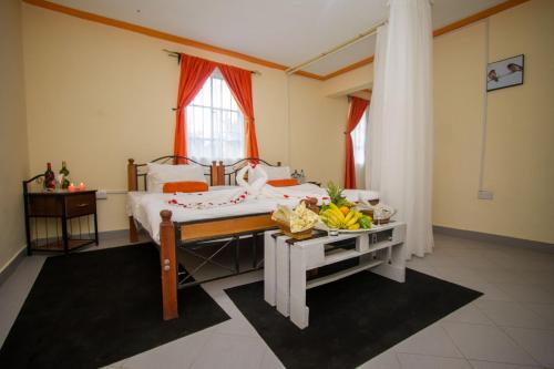 a bedroom with a bed and a table with bananas on it at Dovenest Lodge in Naivasha