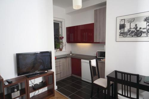 uma cozinha com televisão e uma cozinha com mesa em Judy and Sandor Apartmen em Budapeste