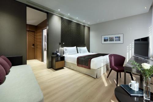 een hotelkamer met een bed en een televisie bij Eurostars Torre Sevilla in Sevilla