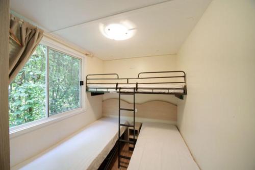 a room with two bunk beds and a window at Camping Solcio in Lesa