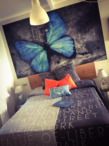 a bedroom with a blue butterfly painting on the wall at Le Storie di Manarola in Manarola