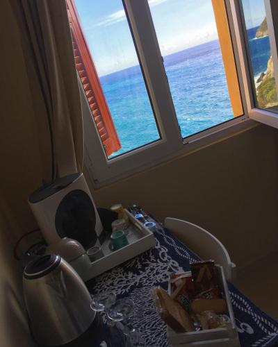 a room with two windows and a tv and the ocean at Le Storie di Manarola in Manarola