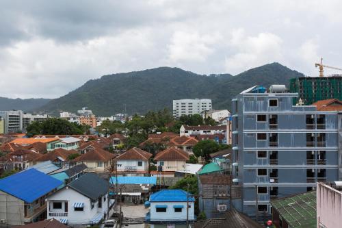 a city with buildings and mountains in the background at Magnific Patong in Patong Beach