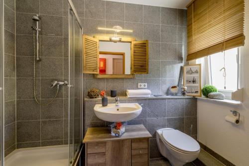 y baño con lavabo, aseo y ducha. en AUSZEIT - Art & Design Ferienapartment, en Bad Endbach