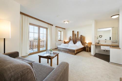 a living room with a couch and a table at Hotel Saliter Hof in Saalfelden am Steinernen Meer