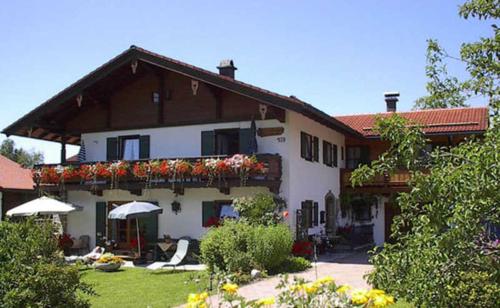 una gran casa blanca con flores en el balcón en Pension mit Bergblick in Inzell, en Inzell