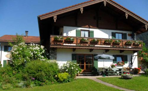 a large house with a balcony with plants on it at Pension mit Bergblick in Inzell in Inzell