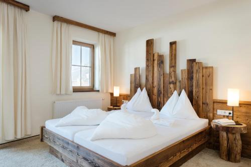 a bedroom with a large bed with white pillows at Hotel Saliter Hof in Saalfelden am Steinernen Meer