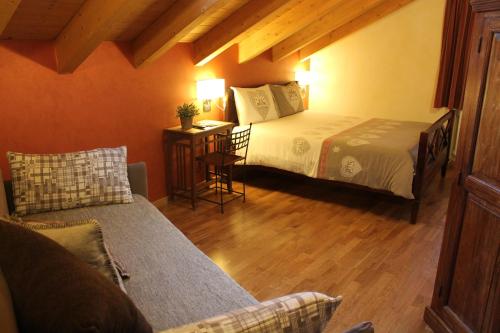 1 dormitorio con 1 cama y 1 sofá en una habitación en B&B Ca' Erminia, en Chiesa in Valmalenco