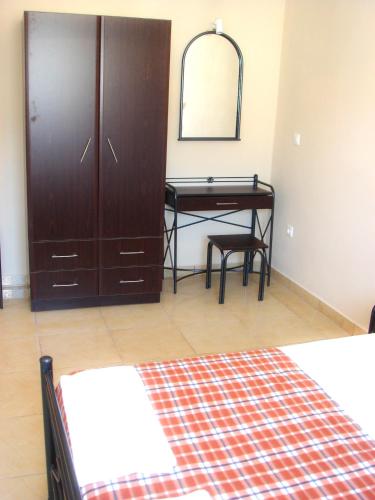a bedroom with a desk and a dresser with a mirror at Dorana Apartments & Trekking Hotel in Diafani