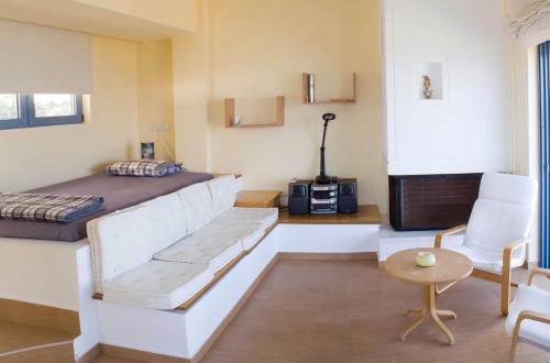 アルテミダにあるBlue Island Suiteのベッドルーム1室(ベッド1台、ソファ、椅子付)