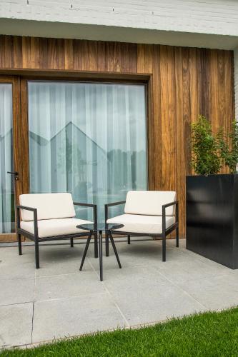 two chairs and a glass table in front of a building at De Koolputten in Waasmunster