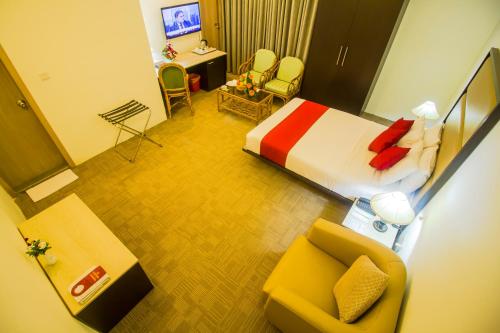 Pokój hotelowy z łóżkiem i krzesłem w obiekcie Asia Pacific Hotel w mieście Dhaka