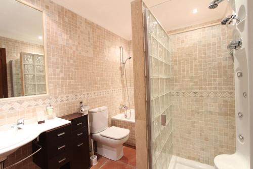 a bathroom with a toilet and a sink and a shower at Villa Puerto Adriano in El Toro