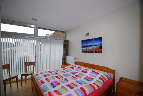 1 dormitorio con 1 cama con un edredón colorido en De Buidel en Meise