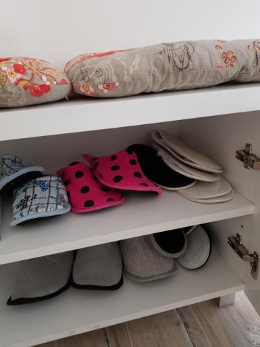 a shelf filled with lots of shoes and pillows at Apartment GEA 1 in Novi Sad