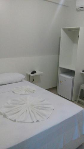 um quarto com uma cama branca e uma mesa branca em Hotel Confiança em Arapiraca