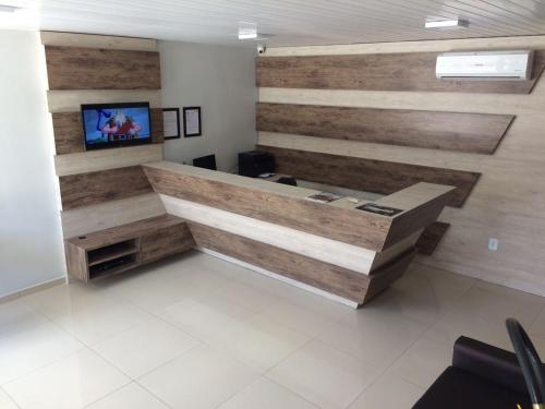 an office with a wooden wall with a desk at Hotel Confiança in Arapiraca