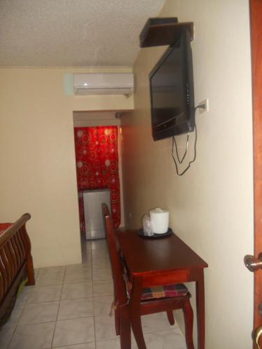 a dining room with a table and a television on a wall at Seaview Inn in Basse Terre Town