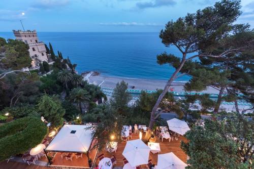 an aerial view of a beach with umbrellas and the ocean at Hotel Punta Est in Finale Ligure