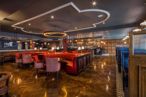 a restaurant with red chairs and a bar at Dublin Skylon Hotel in Dublin