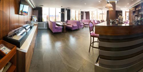 コチェリニキにあるAlva Donna Hotelの紫色の椅子とバーのあるレストラン