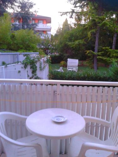 a white table and two chairs and a white fence at Pensione Imperia in Lignano Sabbiadoro