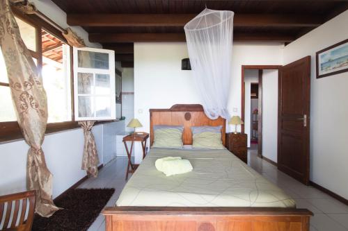 a bedroom with a bed in a room with a window at La douce creole in Mare Poirier