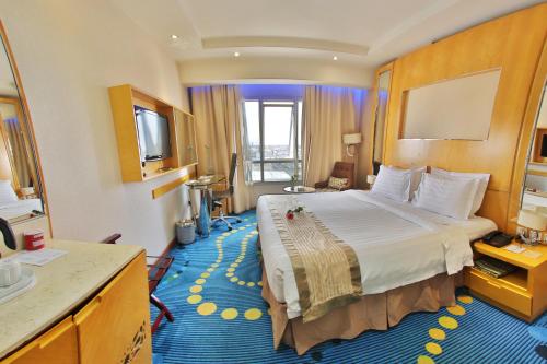 Pokój hotelowy z dużym łóżkiem i telewizorem w obiekcie Dabab Hotel By Warwick w Rijadzie