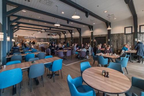 a rendering of a restaurant with tables and chairs at Sommarøy Arctic Hotel Tromsø in Sommarøy