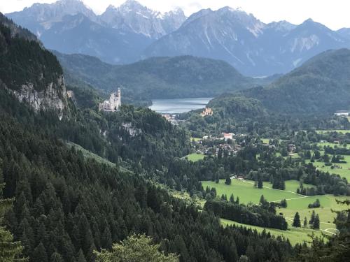 Elle offre une vue sur une vallée avec un château et un lac. dans l'établissement Landhaus & Pension Christian, à Füssen